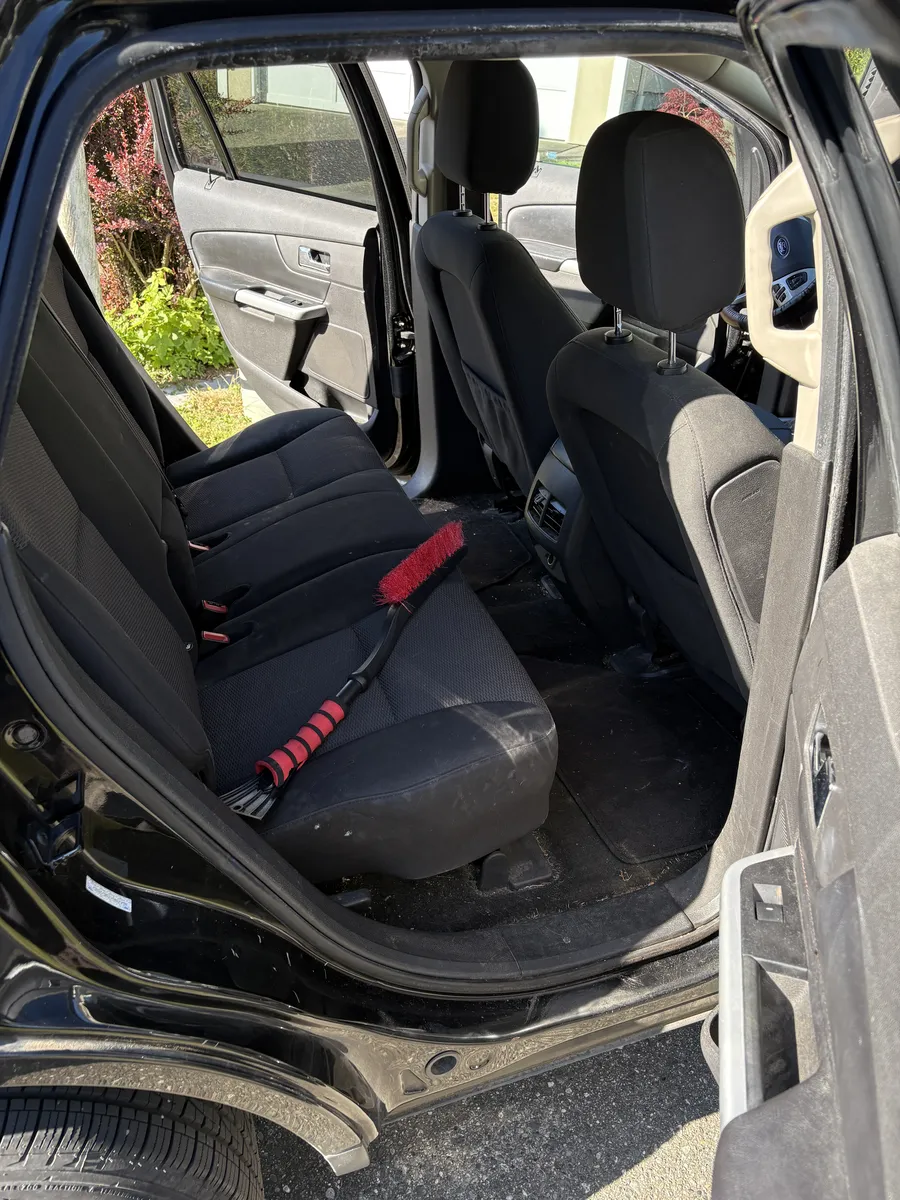 Ford Edge rear seat and floor before the detail, dirty with a snow brush on the seat
