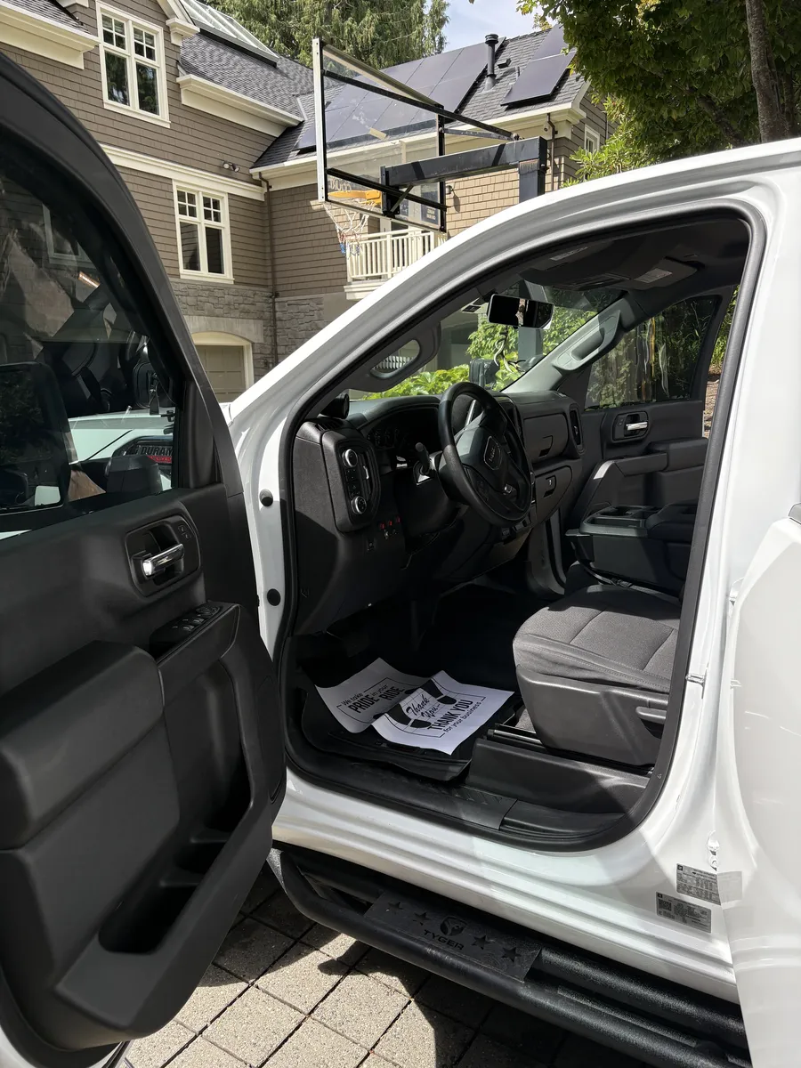 Same white pickup's driver side floor after the detail