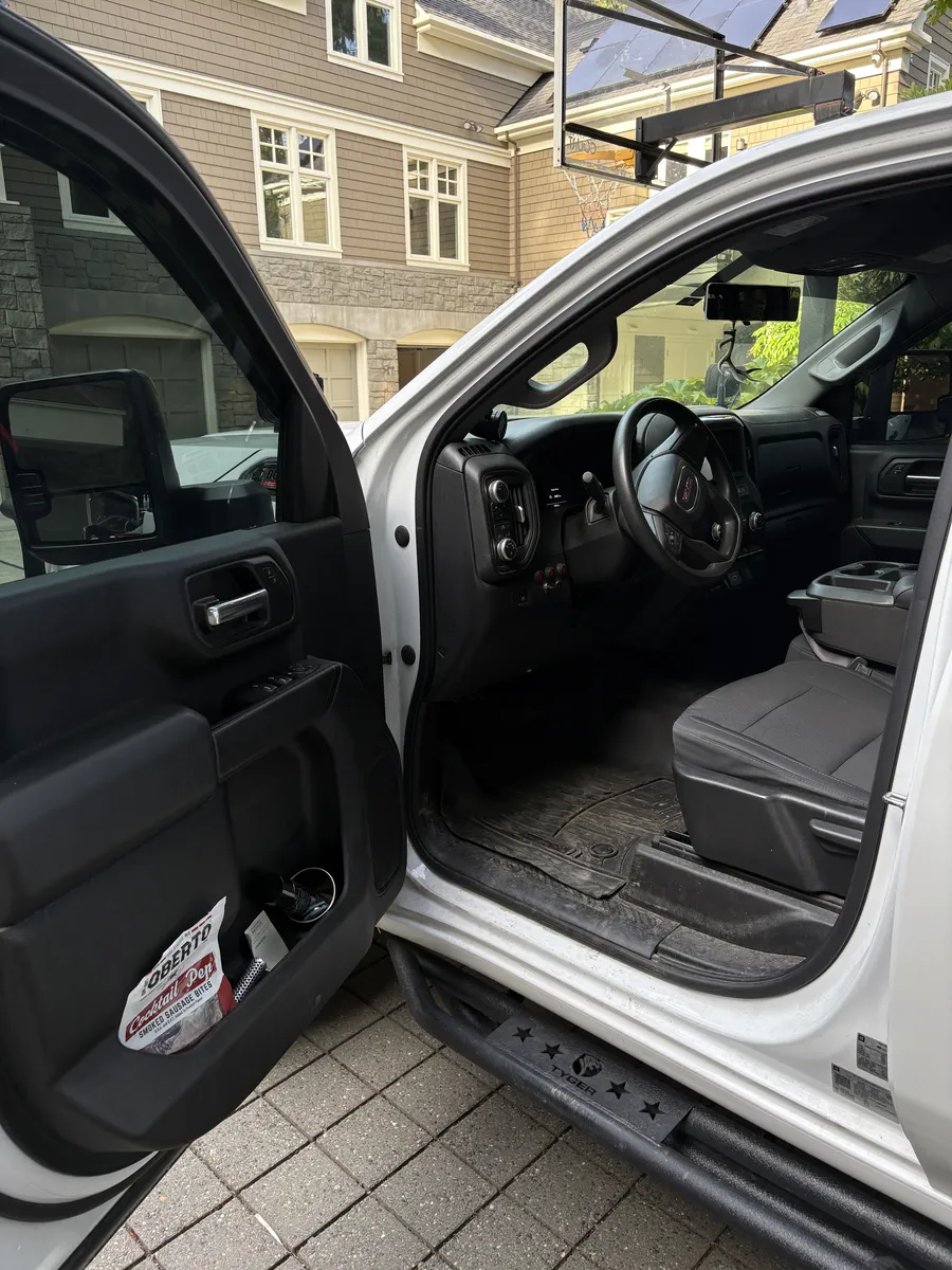 White pickup's driver side floor before the detail, muddy floor mat